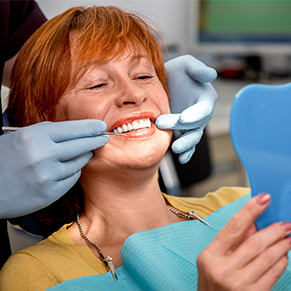 red head woman smiling in dental chair, dental crowns and bridges Hartland, MI